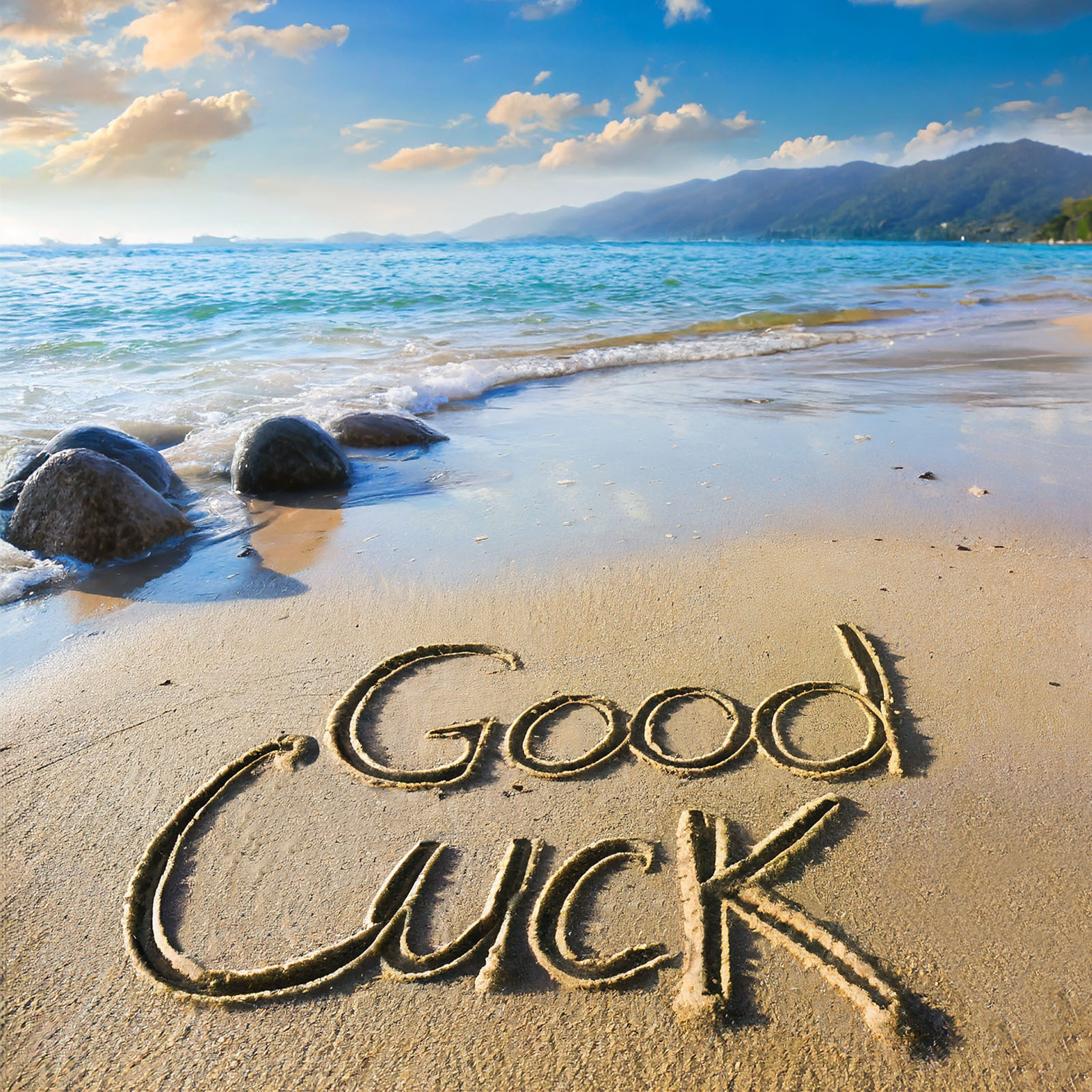 'Good Luck' written in the sand